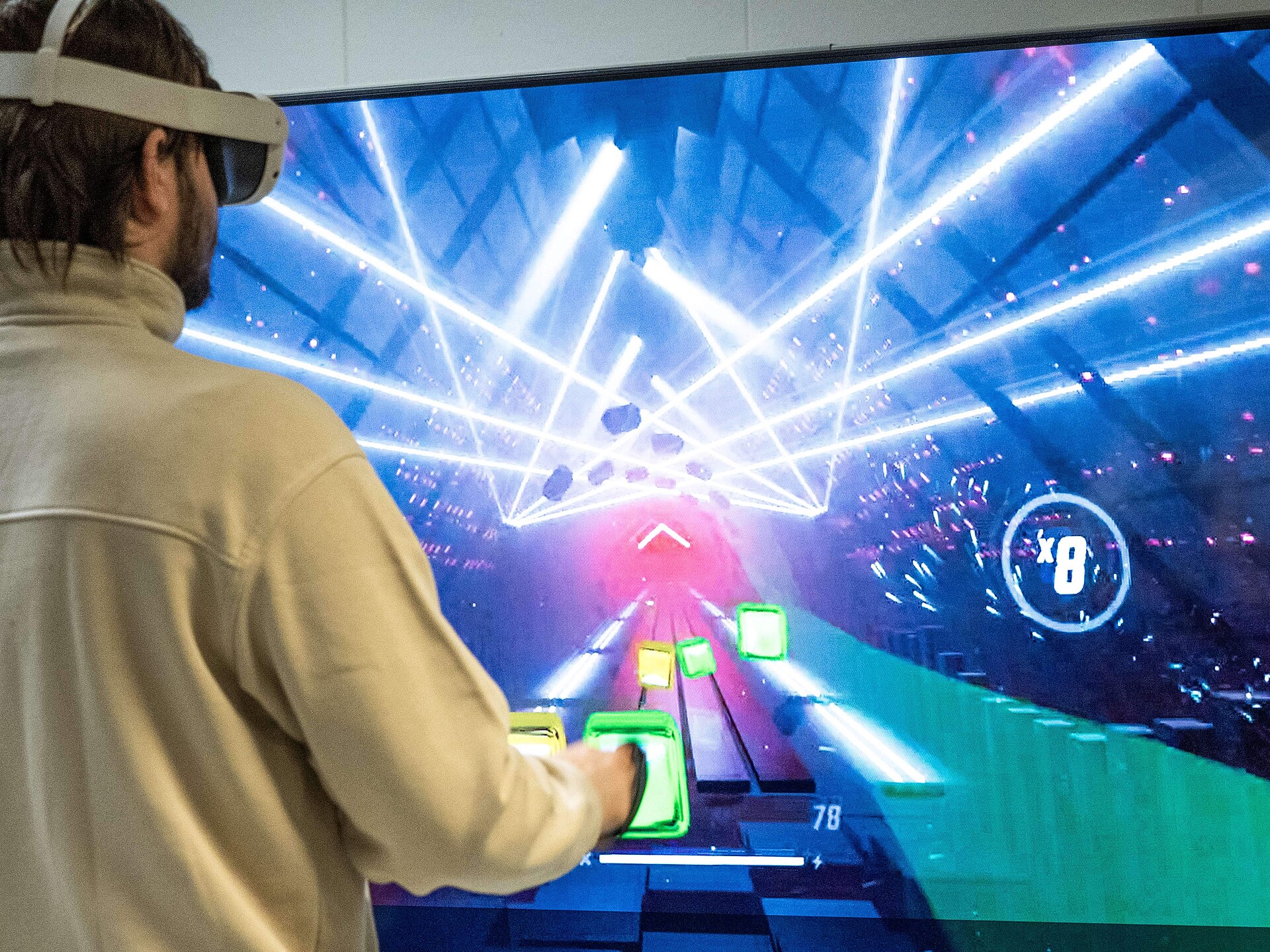 Joueur équipé d’un casque de réalité virtuelle devant un écran de jeu vidéo
